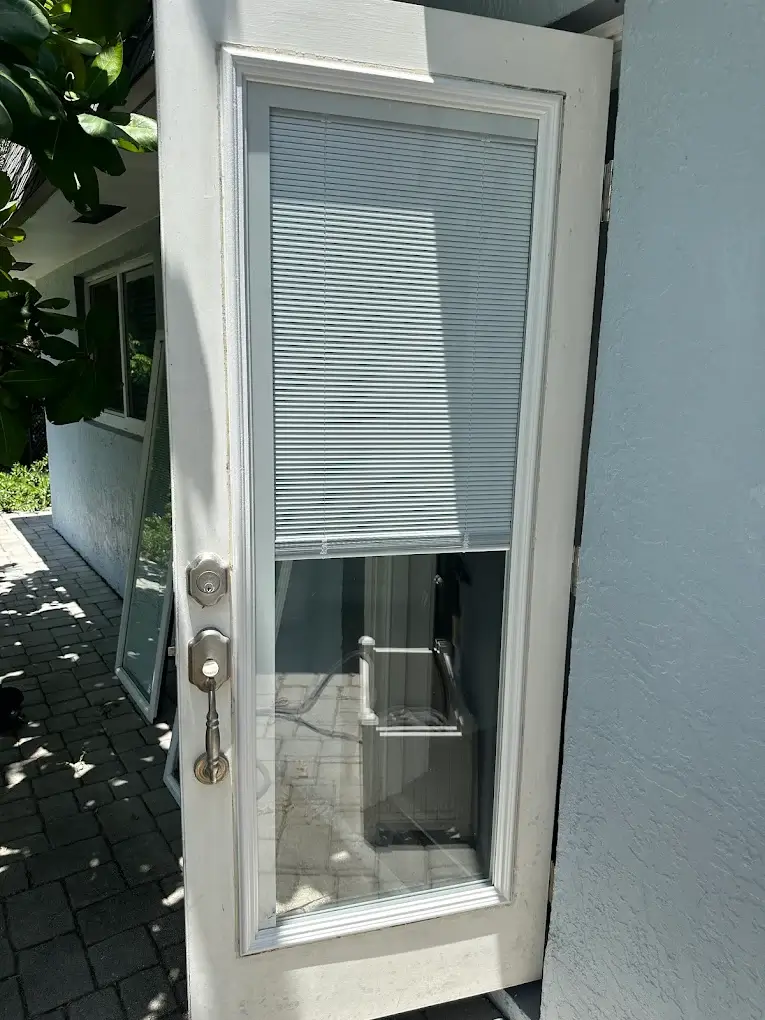 Hinged glass French-style door with built-in blinds and a deadbolt lock